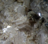 Close-up of thin, bladed bertrandite crystals