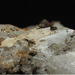 Tan-coloured elpidite alongside a prismatic bundle of leifite