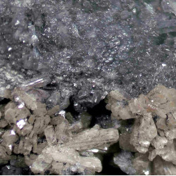 A 1 mm dark grey cluster of pearceite with stellerite